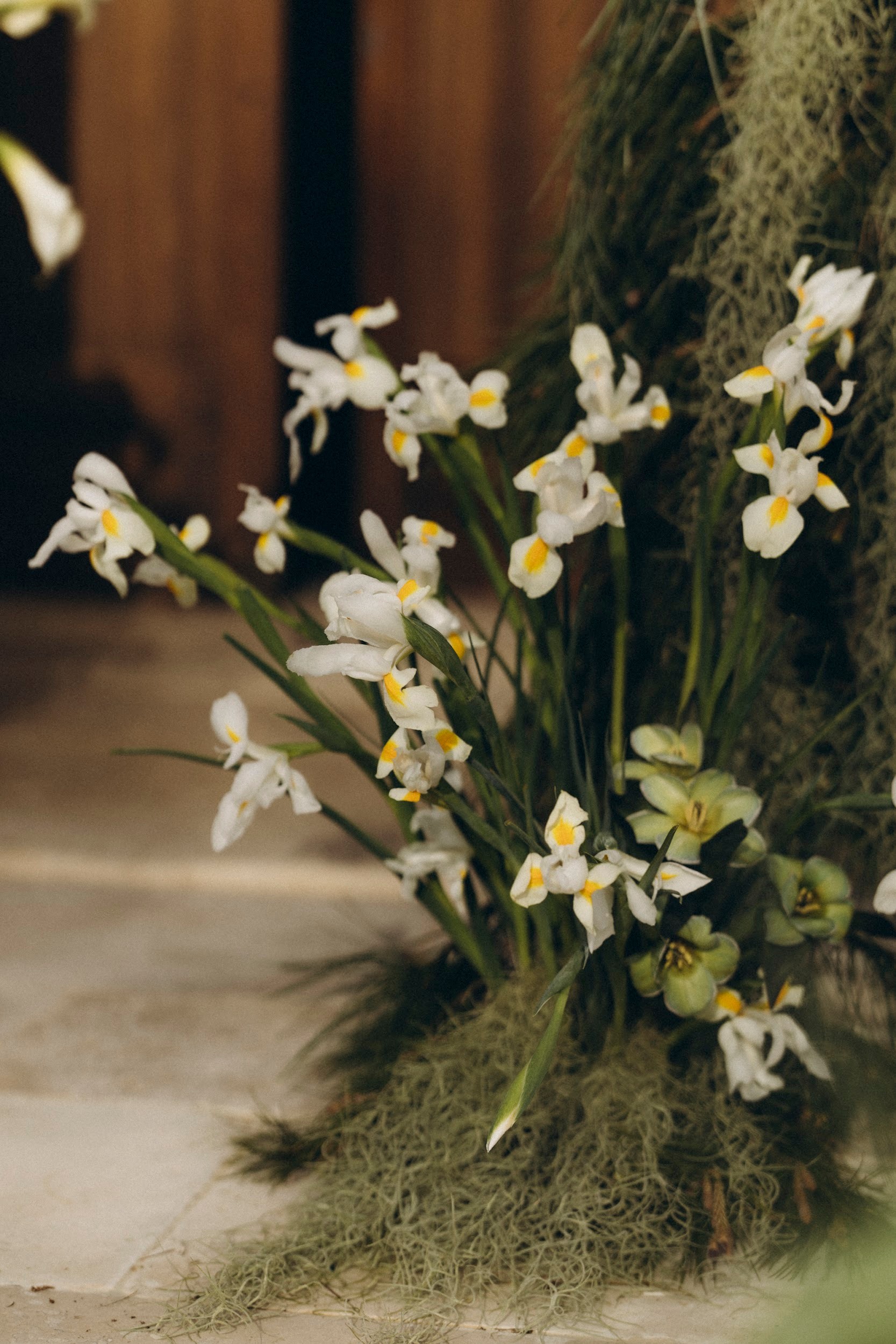 Flottie flower decor, wedding, and organisation at Borgo Lapis in Croatia: detailed shot of elegant white iris and green botanical floral arrangements
