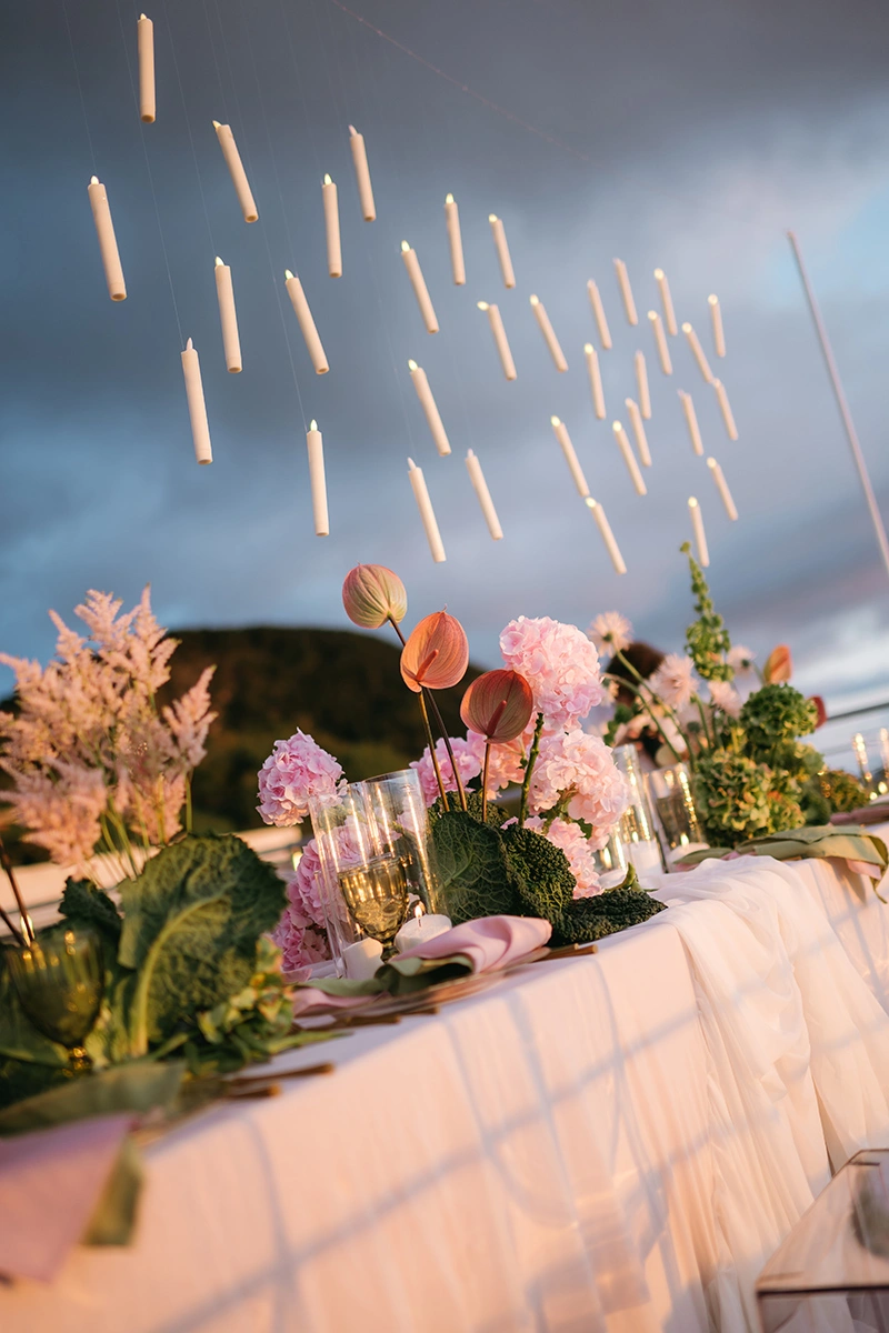 Flottie The Cabbage Affair wedding decor and organisation: elegant outdoor wedding banquet table styled with delicate pink hydrangeas, cabbage leaves, and a magical array of floating candles suspended from above