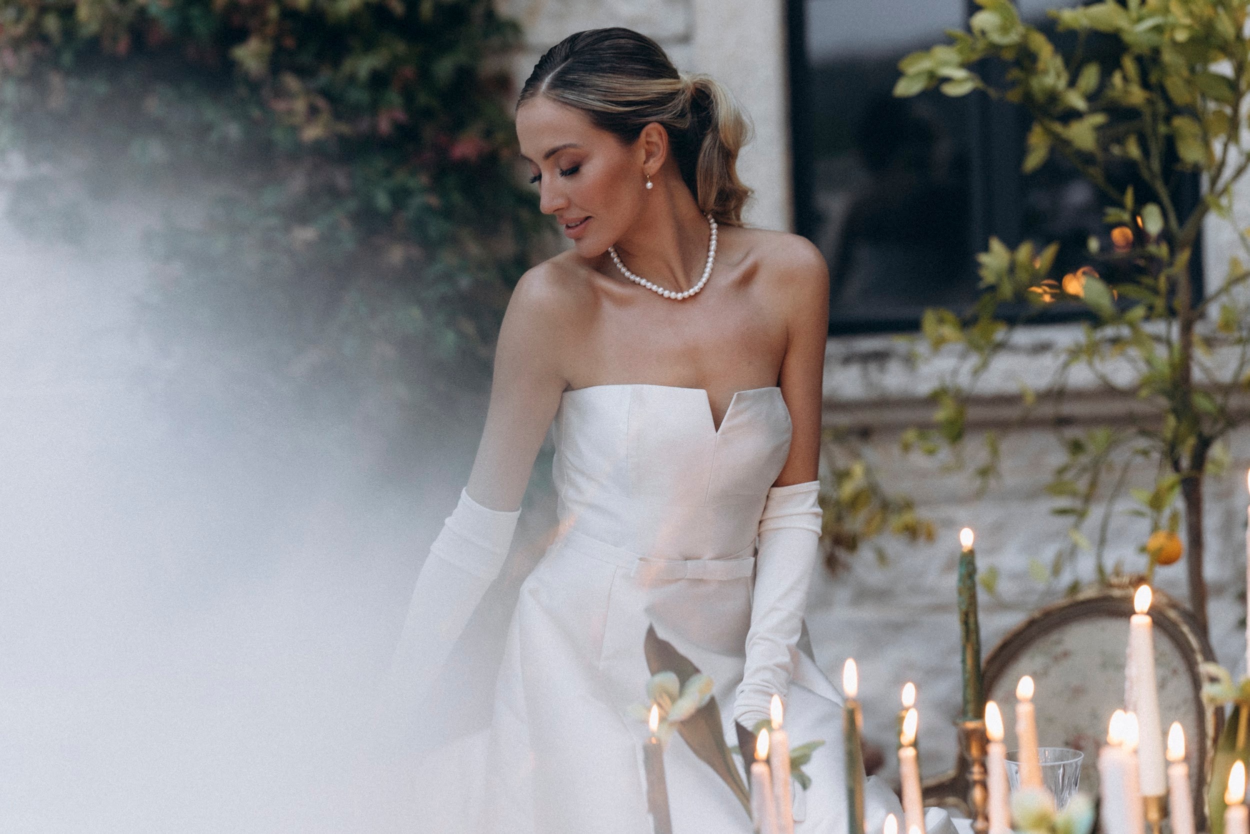 Flottie flower decor, wedding, and organisation at Borgo Lapis in Croatia: portrait of a smiling bride holding a unique bridal bouquet amidst delicate white florals