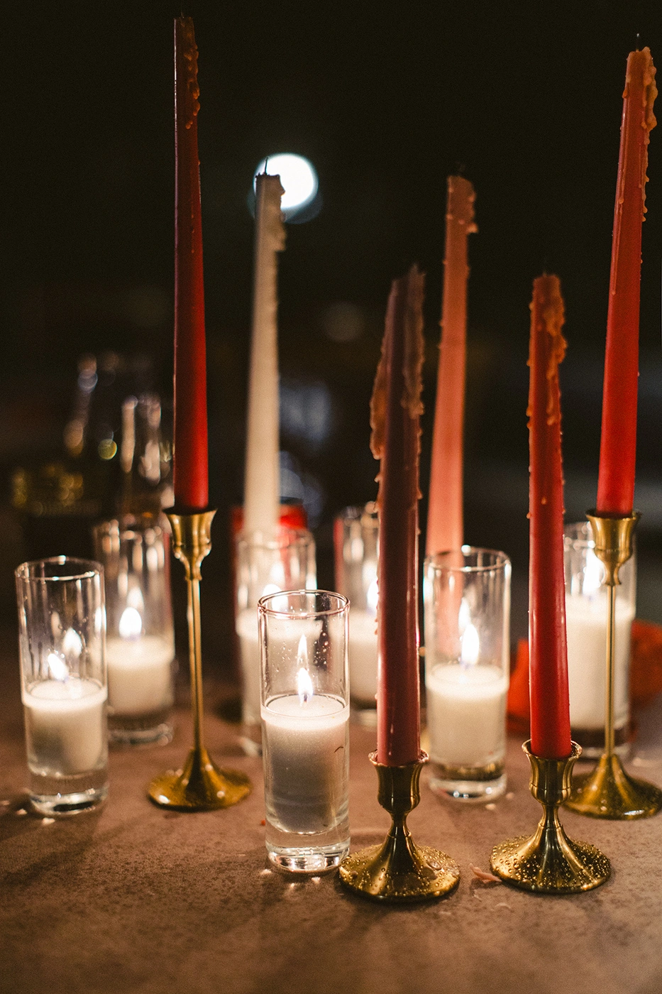 Flottie Peach Haze wedding decor and organisation: aerial view of guests enjoying an outdoor wedding reception dinner at round tables styled with peach-toned florals and candles