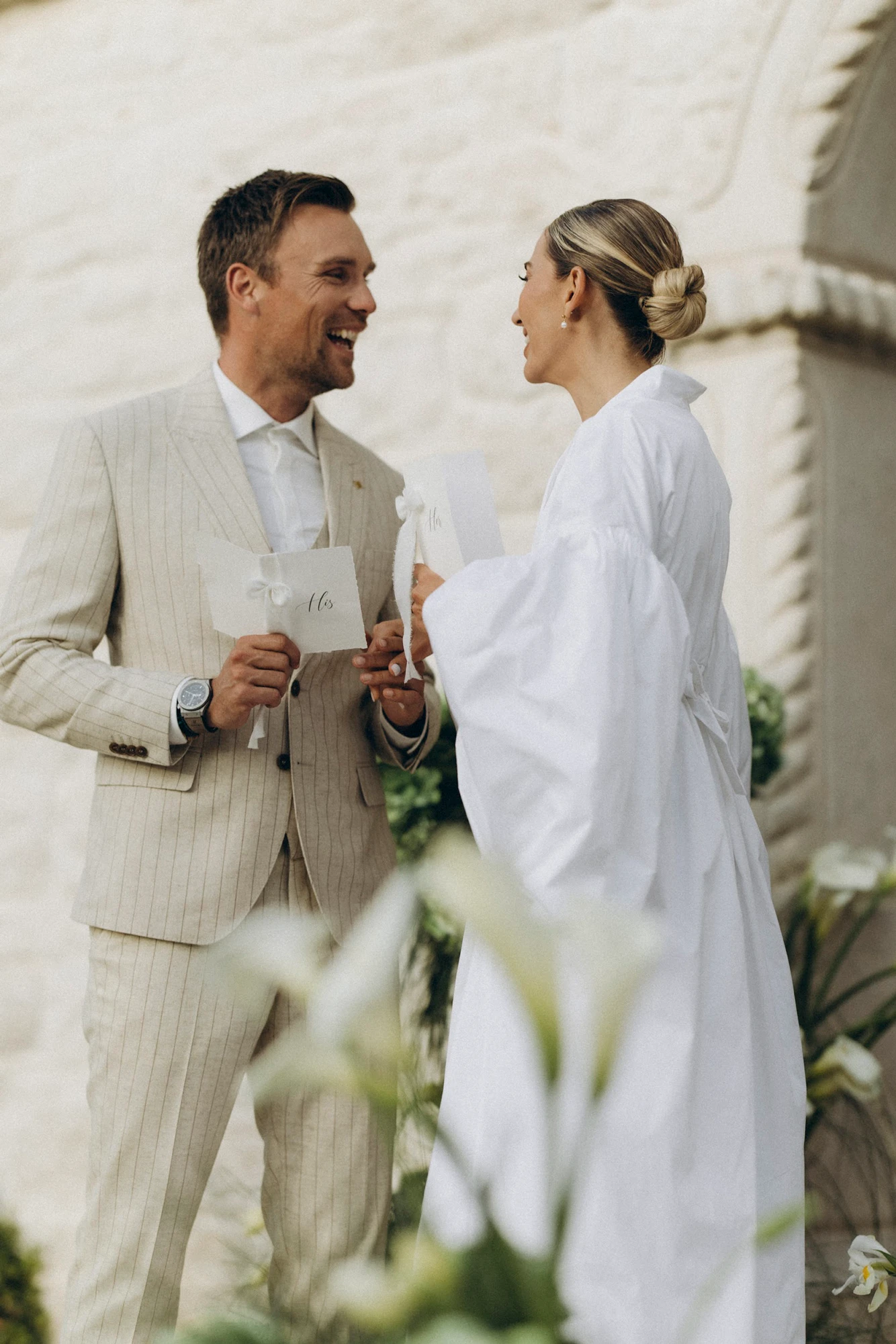 Flottie flower decor, wedding, and organisation at Borgo Lapis in Croatia: couple exchanging vows surrounded by lush green hydrangea and white floral installations against stone architecture