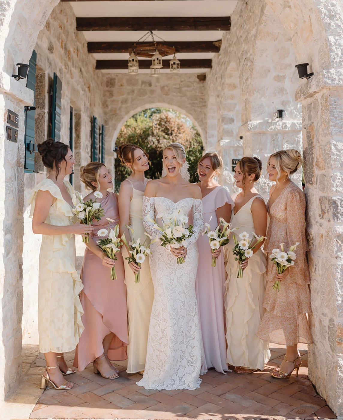 Flottie wedding decor and organisation: portfolio highlights of the Effortless Elegance wedding project showcasing a white calla lily bouquet, the bride with bridesmaids in neutral tones under a stone arch, and refined tableside details