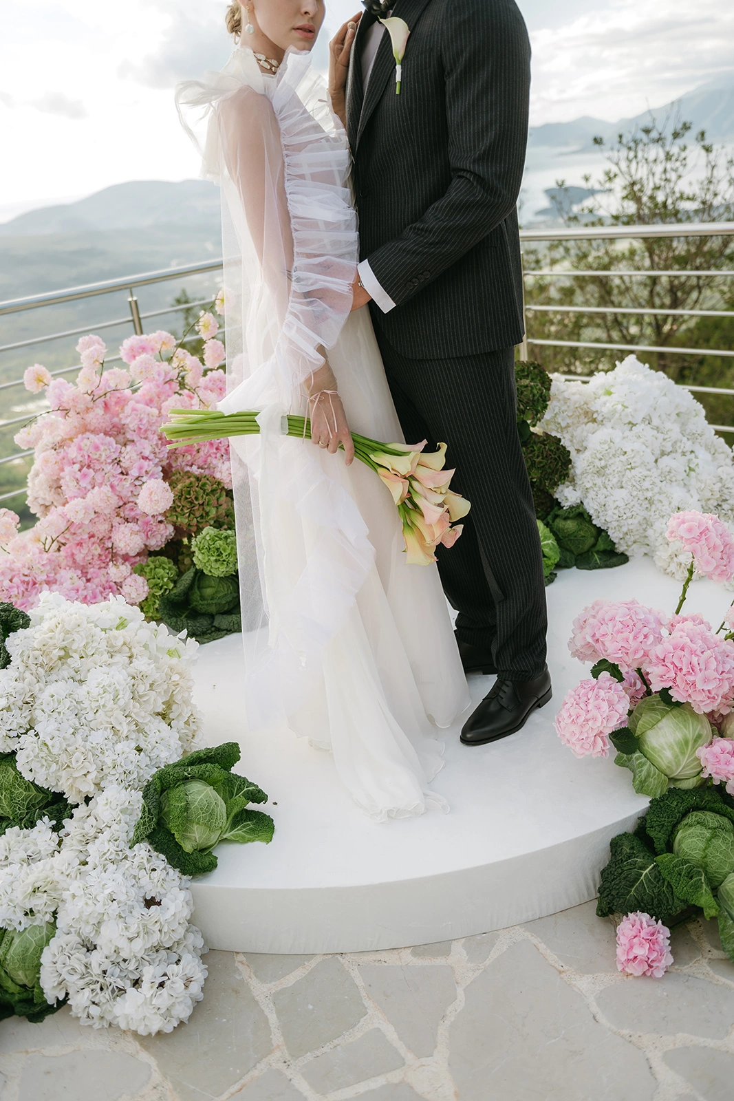 Flottie The Cabbage Affair wedding decor and organisation: enthusiastic bride holding a modern bouquet and groom celebrating joyfully together on stage amid creative floral and cabbage arrangements