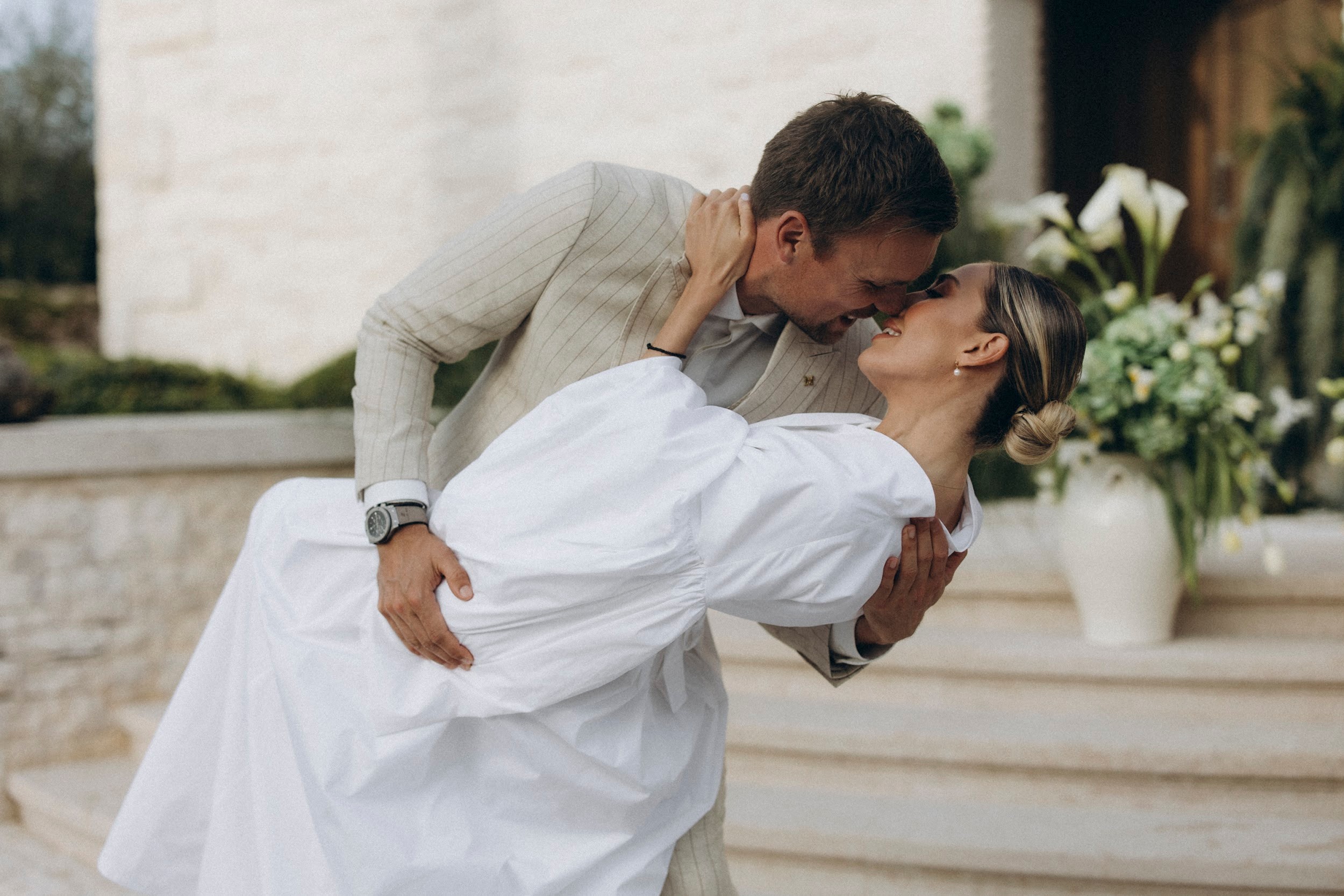 Flottie flower decor, wedding, and organisation at Borgo Lapis in Croatia: couple exchanging vows surrounded by lush green hydrangea and white floral installations against stone architecture