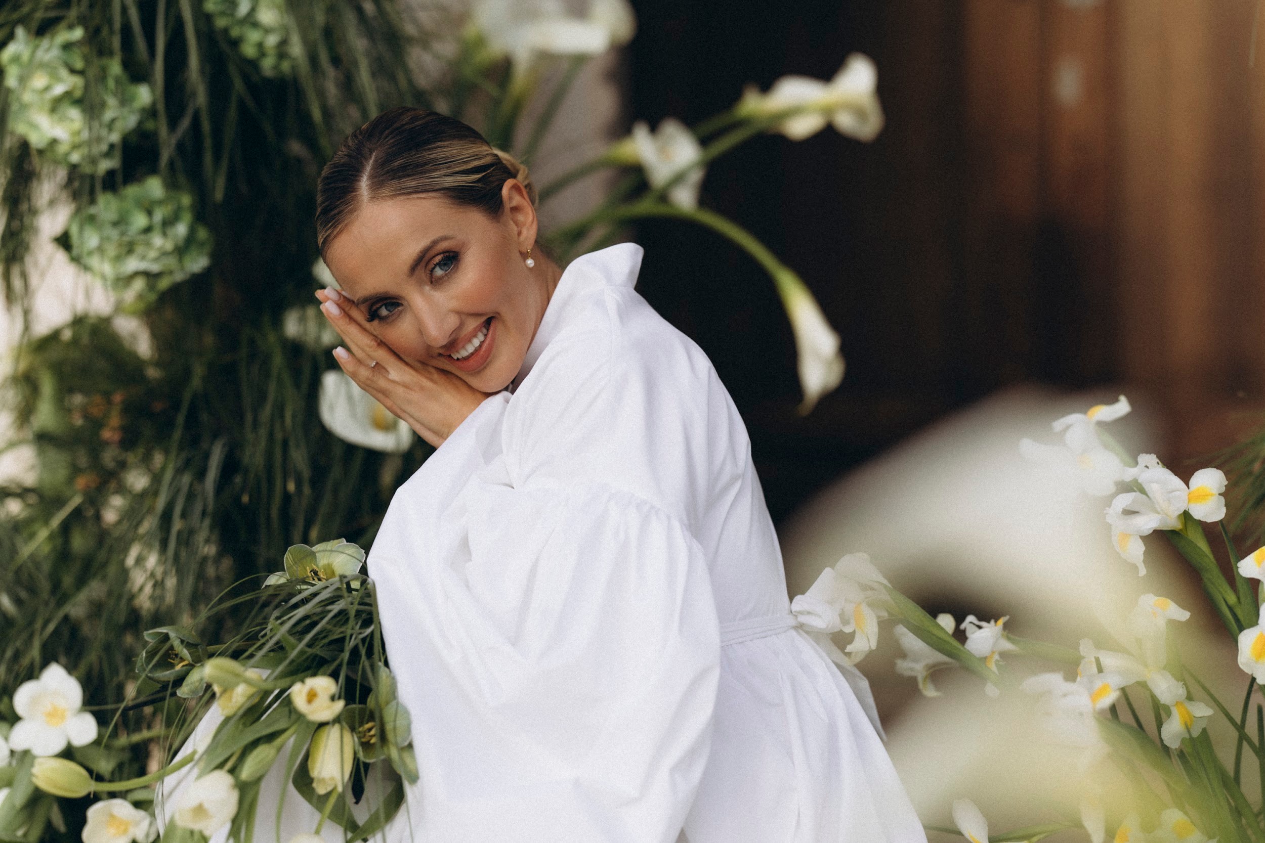 Flottie flower decor, wedding, and organisation at Borgo Lapis in Croatia: portrait of a smiling bride holding a unique bridal bouquet amidst delicate white florals