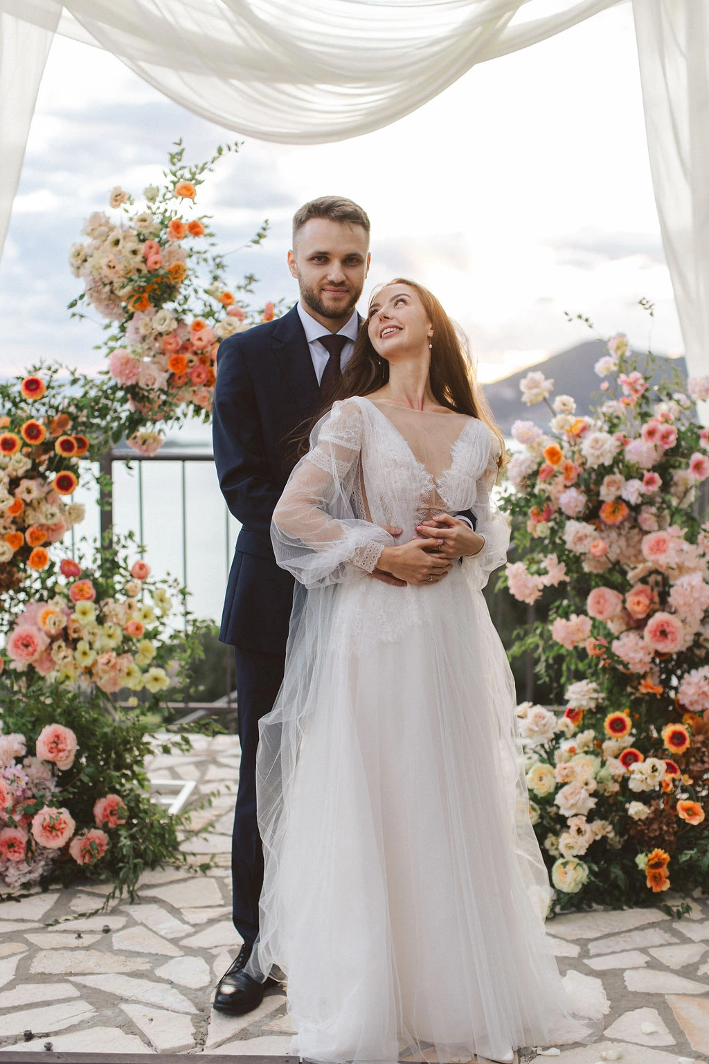 Flottie Peach Haze wedding decor and organisation: portrait of a bride in a lace gown holding a custom peach and pastel bridal bouquet